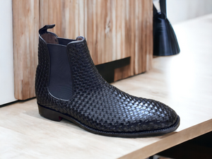 Expertly crafted and stylish, these black woven leather Chelsea boots are the perfect addition to any man's wardrobe. With a sleek and fashionable design, these boots will elevate any outfit while providing comfort and durability. Perfect for any dressy occasion, these handmade boots are a must-have for the modern man.