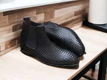 Load image into Gallery viewer, Expertly crafted and stylish, these black woven leather Chelsea boots are the perfect addition to any man&#39;s wardrobe. With a sleek and fashionable design, these boots will elevate any outfit while providing comfort and durability. Perfect for any dressy occasion, these handmade boots are a must-have for the modern man.
